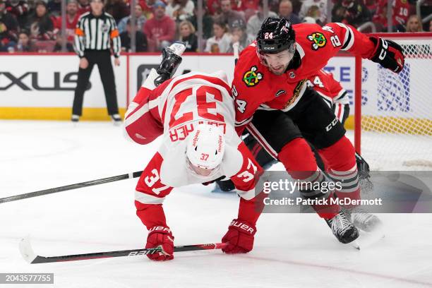 Compher of the Detroit Red Wings is upended by Jaycob Megna of the Chicago Blackhawks during the first period at the United Center on February 25,...