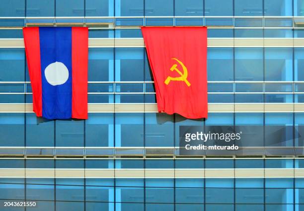 flags of laos and of the ruling communist party (lprp) on a glass façade, vientiane, laos - vientiane stock pictures, royalty-free photos & images