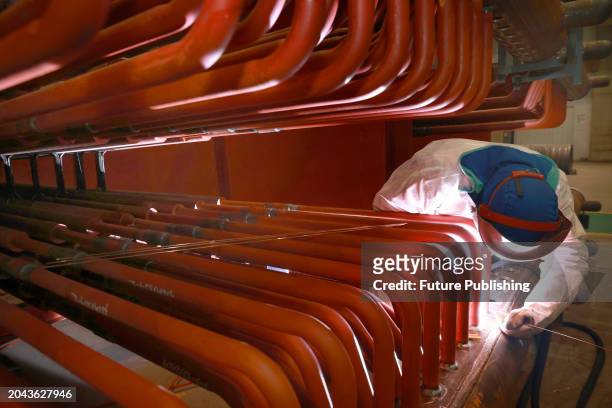 Welder works at a factory of large boilers and electricity generators in Nantong in east China's Jiangsu province.