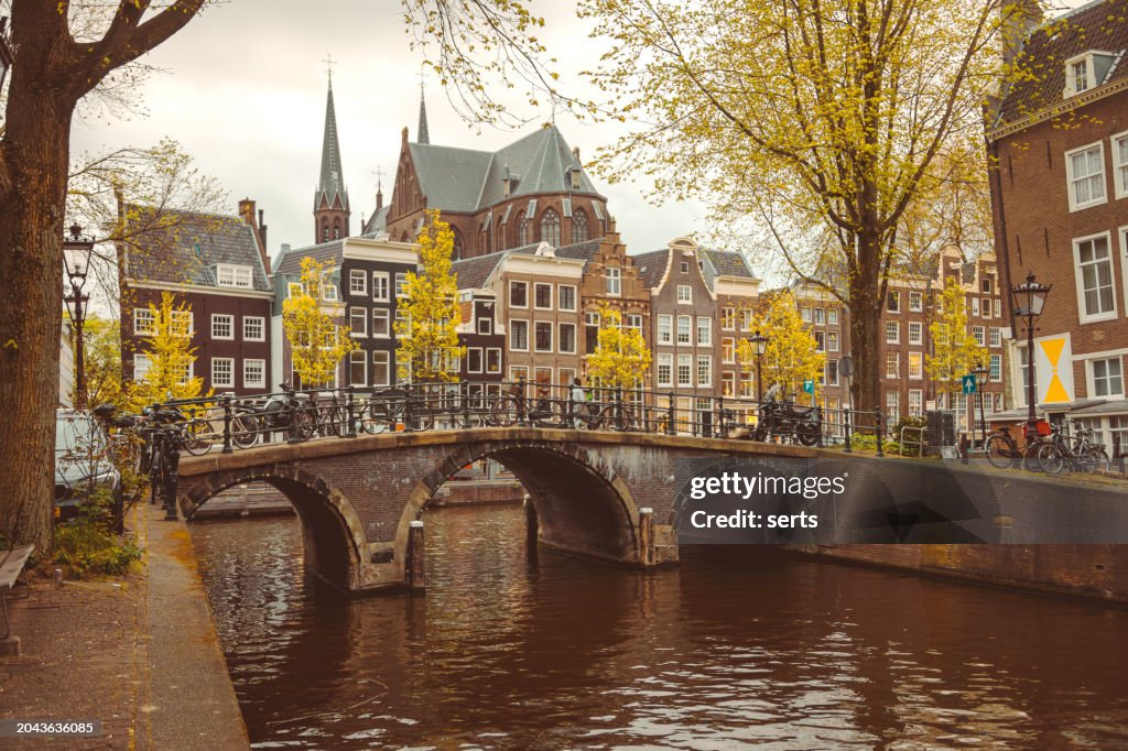 Amsterdam cityscape with canal and bridges in Netherlands.