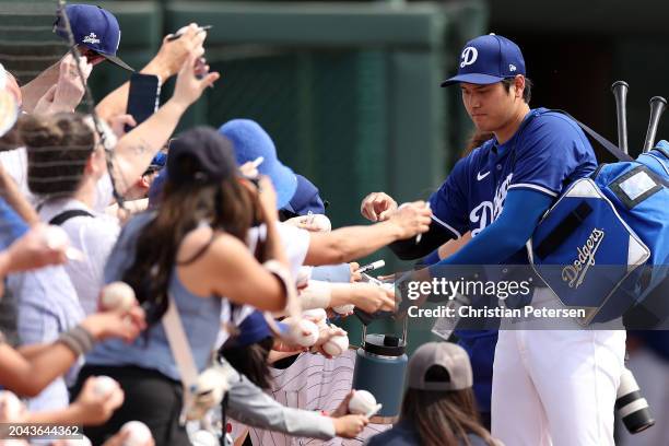 Shohei Ohtani of the Los Angeles Dodgers signs autographs prior to a game against the Chicago White Sox at Camelback Ranch on February 27, 2024 in...