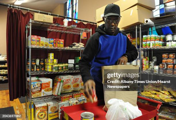 Volunteer Dwight Smith of Albany fills an order at the FOCUS interfaith food pantry in FOCUS Churches of Albany which is housed in Emmanuel Baptist...