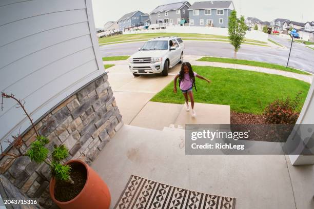 home security camera footage of children coming and going - girl doorbell stockfoto's en -beelden