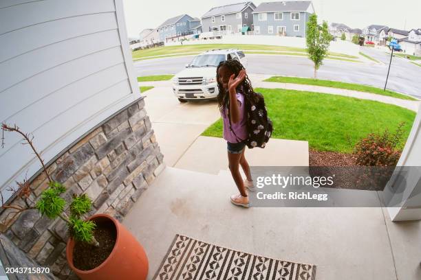 home security camera footage of children coming and going - girl doorbell stockfoto's en -beelden