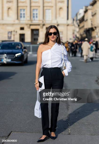 Ann-Laure Mais wears white asymmetric button shirt, black high waisted pants, white bag, sunglasses outside Dior during the Womenswear Fall/Winter...