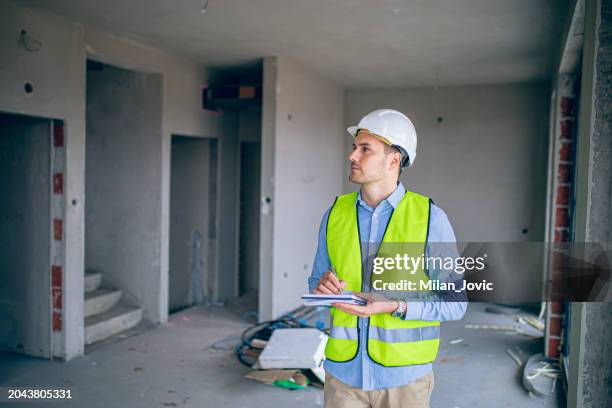 male architect on construction site - calidad fotografías e imágenes de stock