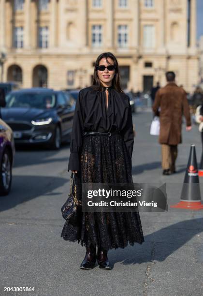 Nina Urgell Cloquell wears high waisted transparent laced skirt, blouse, black bag, cowboy boots outside Dior during the Womenswear Fall/Winter...