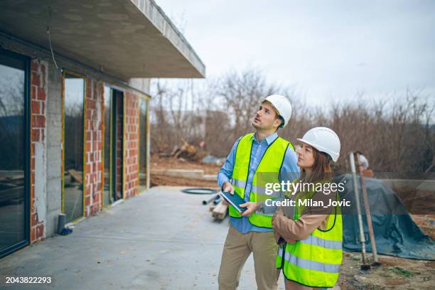 architects discussing plan at construction site - business man overseeing blueprints outdoor stock-fotos und bilder