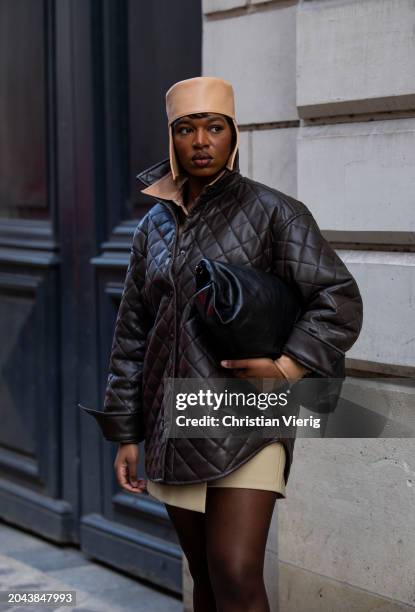 Loicka Grace wears beige hat, brown quilted jacket, black bag, beige skirt, tights outside Ester Manas during the Womenswear Fall/Winter 2024/2025 as...