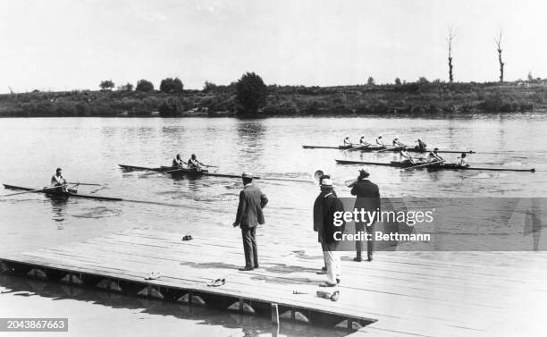 American rowing crews in a trial spin on the Seine. Coach Muller formerly of Harvard with a megaphone.