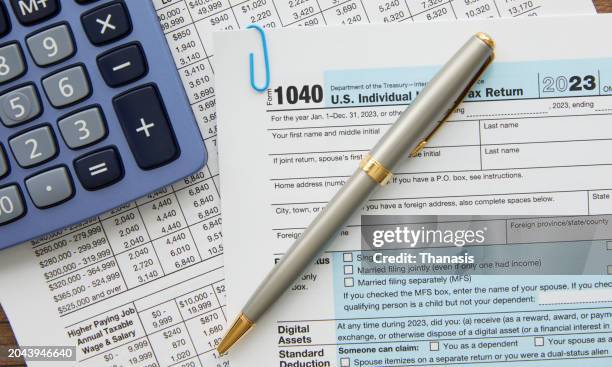 tax form with a calculator - tasse foto e immagini stock