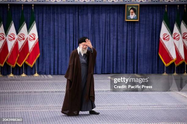 Iran's supreme leader Ayatollah Ali Khamenei walks past Iranian flags after casting his vote in the parliamentary elections and the elections for the...
