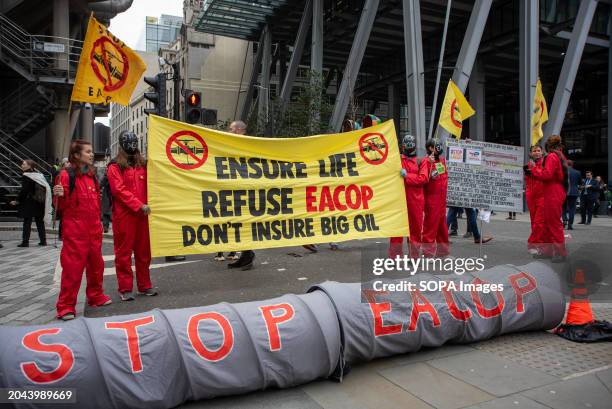 Protesters hold flags and banner by the Lloyd's Insurance Company during the demonstration. Extinction Rebellion organised a week long campaign...