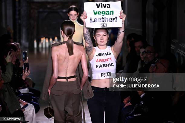 An activist of People for the Ethical Treatment of Animals takes to the catwalk to protest against the use of leather in the fashion industry, as...