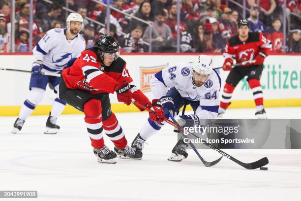 New Jersey Devils defenseman Luke Hughes and Tampa Bay Lightning center Tyler Motte battle for the puck during a game between the against the against...