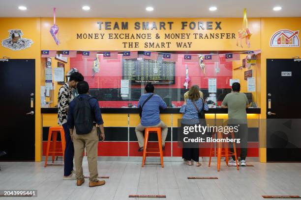 Customers at a currency exchange store in Kuala Lumpur, Malaysia, on Friday, March. 1, 2024. Policymakers have stepped up their rhetoric to rein in...