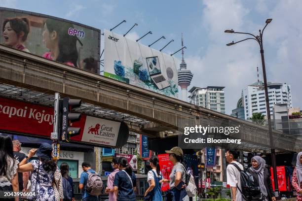 Pedestrians along a road in Kuala Lumpur, Malaysia, on Friday, Feb. 23, 2024. Malaysia's varied attractions now have added appeal thanks to the weak...