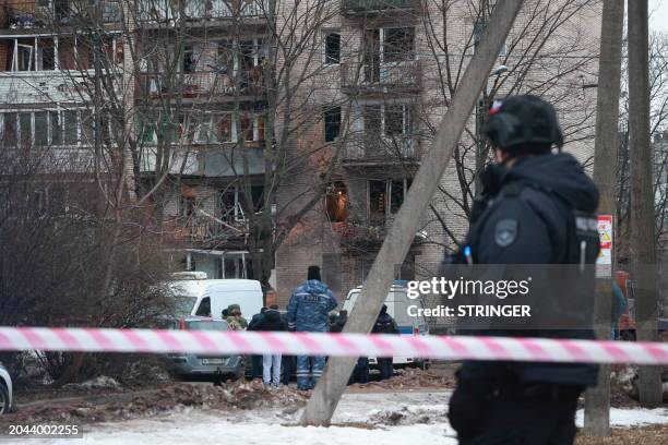 Emergency services specialists work by a damaged apartment block after an alleged drone attack reported by local media, in Saint Petersburg on March...
