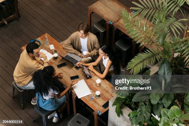 college friends studying together at coffee shop - cafe stock pictures, royalty-free photos & images