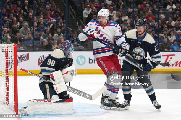 Adam Boqvist of the Columbus Blue Jackets battles Chris Kreider of the New York Rangers for position in front of Elvis Merzlikins of the Columbus...