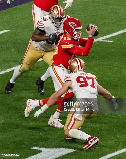 Quarterback Patrick Mahomes of the Kansas City Chiefs tries to avoid being tackled by defensive end Nick Bosa and defensive tackle Javon Hargrave of...