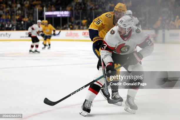 Travis Hamonic of the Ottawa Senators and Cole Smith of the Nashville Predators compete for the puck in the first period at Bridgestone Arena on...