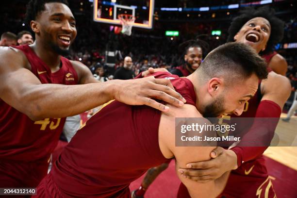 Donovan Mitchell and Isaac Okoro celebrate with Max Strus of the Cleveland Cavaliers after Strus made a half-court buzzer-beater shot to defeat the...