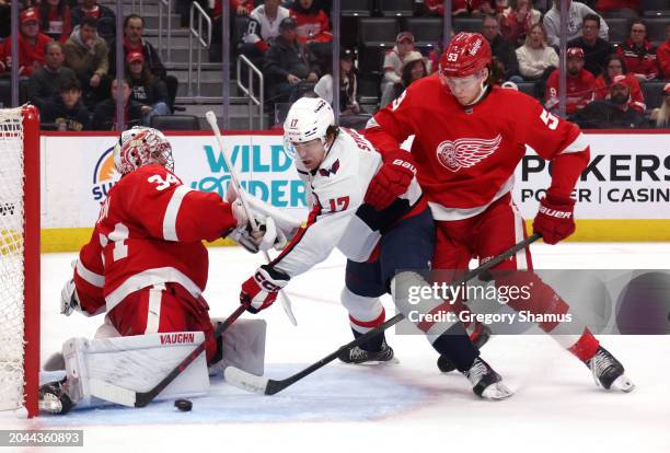 Dylan Strome of the Washington Capitals gets his shot blocked while between Alex Lyon and Moritz Seider of the Detroit Red Wings during the third...