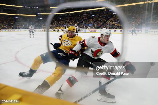 Yakov Trenin of the Nashville Predators battles Jacob Bernard-Docker of the Ottawa Senators along the boards in the first period at Bridgestone Arena...