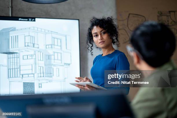 boost brainstorming sessions and idea generation within construction teams to driven construction projects. designers at the office discuss a project design on a projection screen for review of structure and material next to the construction phase. - cad drawing stock pictures, royalty-free photos & images