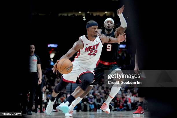 Jimmy Butler of the Miami Heat dribbles the ball while defended by Jerami Grant of the Portland Trail Blazers during the second half at Moda Center...