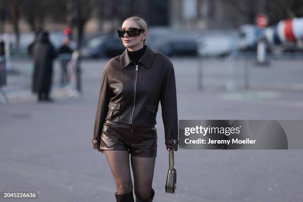 Justyna Czerniak seen wearing YSL brown tortoise sunglasses, gold earrings, black turtleneck cotton top, brown leather cropped jacket, matching brown...