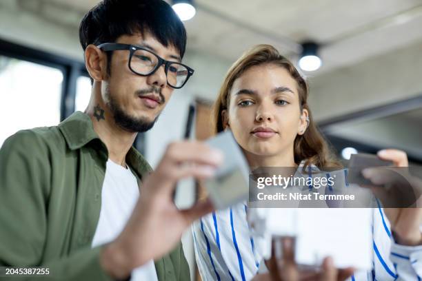 design low-carbon in project development process to more environmentally-aware customers. diversity of team designers is discussing their projects design while choosing materials for construction, reduce carbon in the design process. - zero energy building stock pictures, royalty-free photos & images