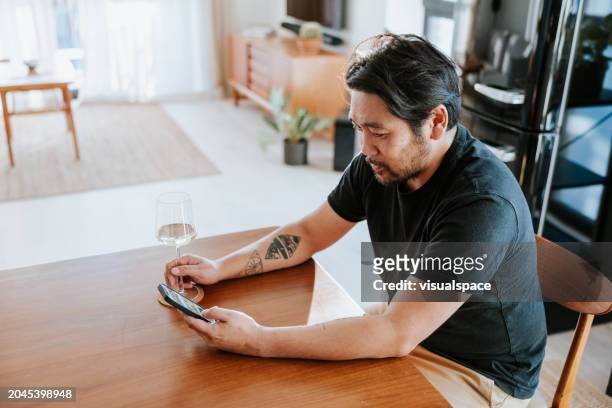 japanese man using food delivery app at home - wine home delivery stock pictures, royalty-free photos & images