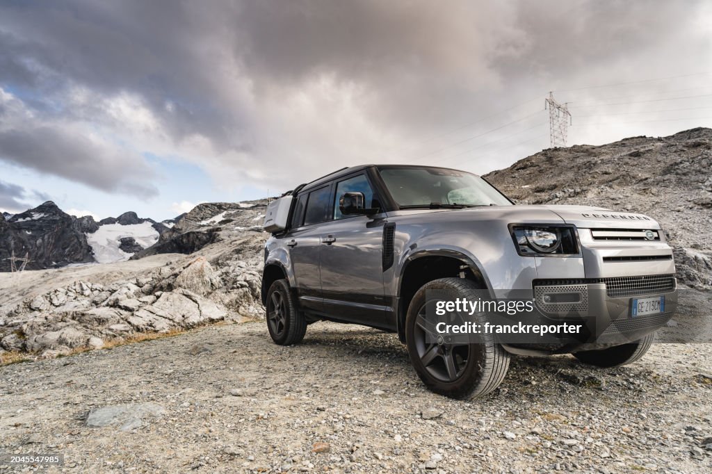 Land Rover Defender against the alps at Passo dello Stelvio close to Bormio