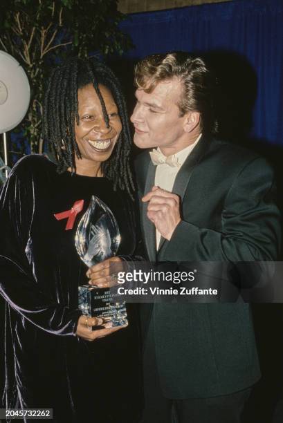American actor, singer and dancer Patrick Swayze, wearing a black tuxedo with a white bow tie, and American actress and comedian Whoopi Goldberg, who...