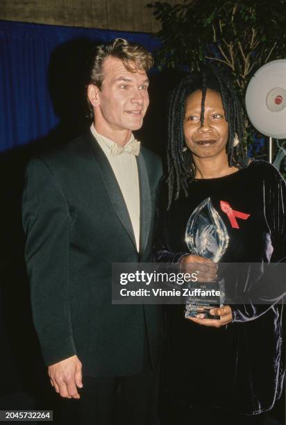 American actor, singer and dancer Patrick Swayze, wearing a black tuxedo with a white bow tie, and American actress and comedian Whoopi Goldberg, who...