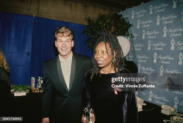 American actor, singer and dancer Patrick Swayze, wearing a black tuxedo with a white bow tie, and American actress and comedian Whoopi Goldberg, who...