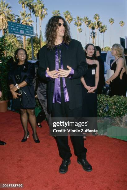 American radio host and 'shock jock' Howard Stern, who wears a black suit over a purple shirt, and American radio host Robin Quivers, who wears a...