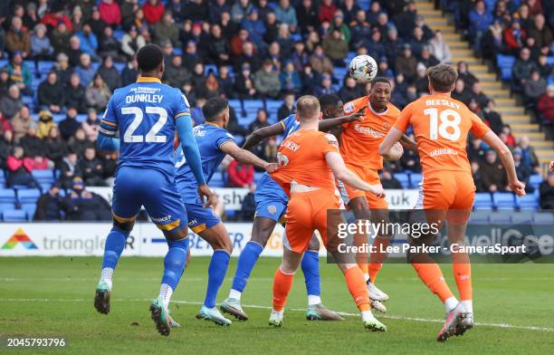 Blackpool's Marvin Ekpiteta heads the ball at goal under pressure from Shrewsbury Town's Max Mata during the Sky Bet League One match between...