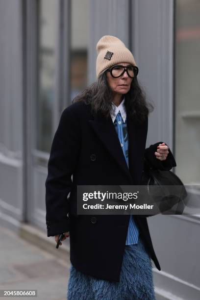 Guest seen wearing Louis Vuitton beige wool knit logo beanie, black glasses, blue / black striped print pattern buttoned shirt with white collar,...