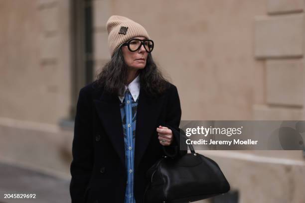 Guest seen wearing Louis Vuitton beige wool knit logo beanie, black glasses, blue / black striped print pattern buttoned shirt with white collar,...