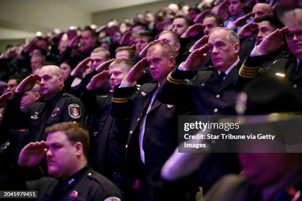 Members of law enforcement salute as the caskets representing the fallen as they are brought into the sanctuary at Grace Church at the start of the...