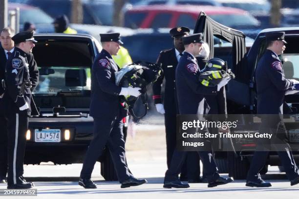 Burnsville, Minn. Firefighters carry Adam Finseths uniform to a memorial service for Burnsville police officers Paul Elmstrand Matthew Ruge and...