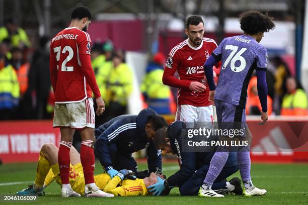 Nottingham Forest's Belgian goalkeeper Matz Sels receives medical attention after a foul by Liverpool's English striker Jayden Danns during the...