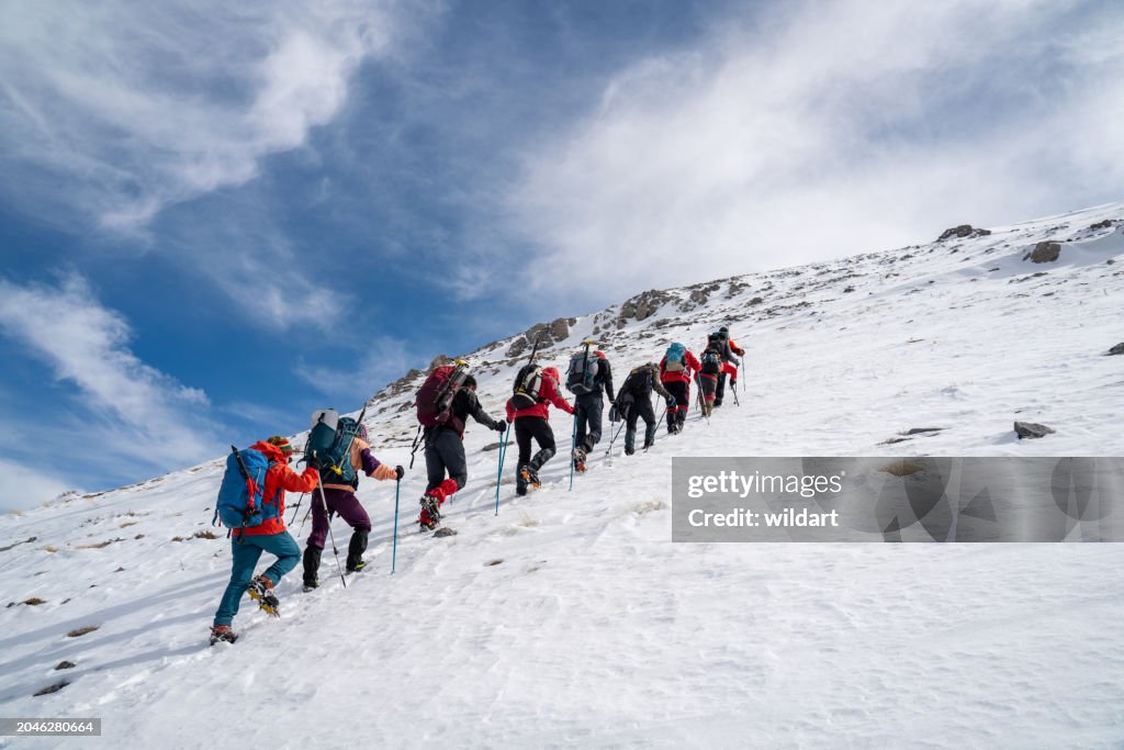 Mountain climber team is walking on the mountain while watching the beautiful landscape of mountain summit.
