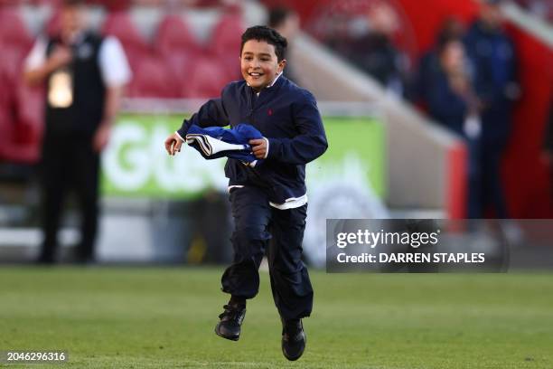 Young fan runs after getting the shirt of Chelsea's English midfielder Raheem Sterling at the end of the English Premier League football match...