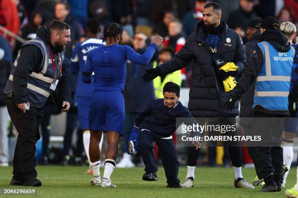 Young fan avoids security after getting the shirt of Chelsea's English midfielder Raheem Sterling at the end of the English Premier League football...