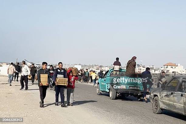 In this image grab from an AFPTV video, people carry food parcels that were airdropped from US aircrafts above a beach in the Gaza Strip, on March 2,...