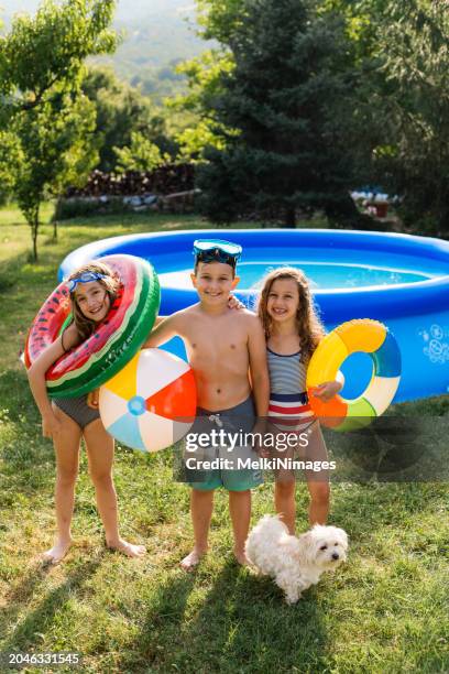 kinder genießen den sommer im aufblasbaren pool im hof - gartenpool stock-fotos und bilder